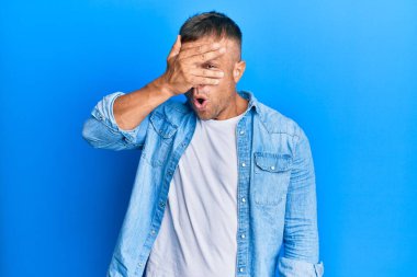 Yakışıklı, sıradan bir kot ceket giyen, yüzünü ve gözlerini kapatan, parmaklarından korkan kaslı bir adam. 