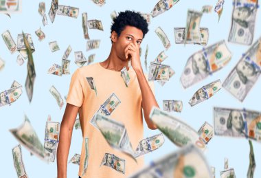 Genç, Afro-Amerikan bir adam günlük giysiler giymiş pis ve iğrenç bir koku alıyor, dayanılmaz bir koku, parmakları burnunda nefesini tutuyor. Kötü kokuyor.