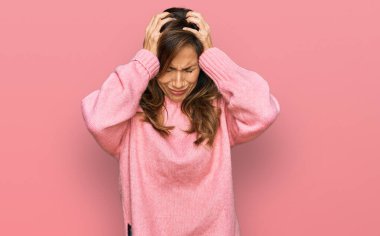 Genç İspanyol kadın gündelik kıyafetler giyiyor. Baş ağrısı, çaresiz ve stresli. Ağrı ve migren yüzünden. Eller başının üstünde.. 