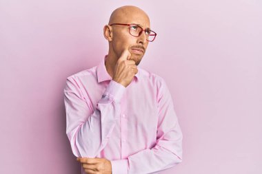 Sakallı, sıradan kıyafetler giyen, gözlüklü, kuşkuyu düşünen, çenesinde parmak olan kel bir adam. 