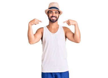 Gündelik yaz şapkası takan, kendine güvenen, gülümseyen, kendini gururlu ve mutlu gösteren İspanyol genç bir adam.. 