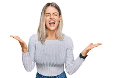 Güzel sarışın kadın gündelik giysiler giyip başarının çılgınlığını kutluyor. Kollarını kaldırmış, gözlerini kapatmış heyecanlı bir şekilde bağırıyor. Kazanan konsept 