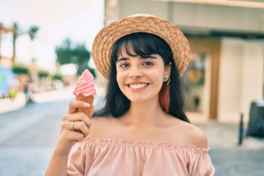 Yaz tarzı giyinen İspanyol turist kız şehirde dondurma yiyor..