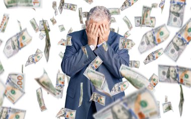 Yaşlı, gri saçlı, iş ceketi giyen, suratını ellerle örten ve ağlayan bir adam. depresyon kavramı.