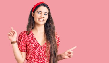 Yazlık elbise giyen esmer genç kız farklı yönleri gösteren kendine güvenle gülümsüyor. reklam için kopyalama alanı 