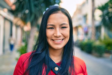 Genç Latin kadın gülümseyerek şehirde mutlu mesut yürüyor..