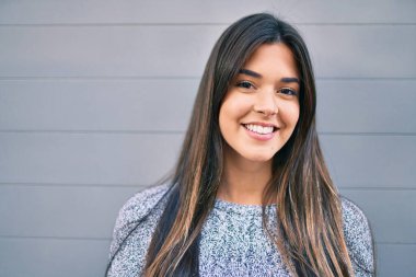 Genç ve güzel İspanyol kız gülümseyerek şehirde mutlu mesut yürüyor..