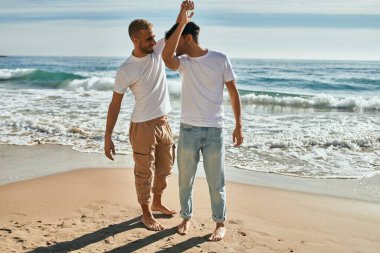 Genç eşcinsel çift gülümsüyor Kumsalda dans ederken mutlu.