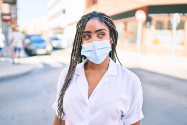 Güneşli bir yaz gününde açık havada örgü ören Afro-Amerikalı genç bir kadın.