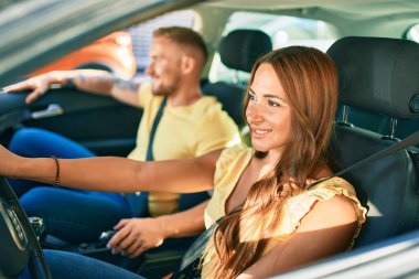 Gülümseyen mutlu araba kullanan genç çift.,