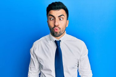 İş kıyafetleri giymiş genç bir İspanyol dudaklarıyla balık suratı yapıyor, çılgınca ve komik bir jest. Komik ifade. 