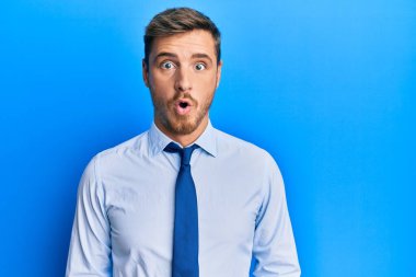 İş gömleği ve kravat takan yakışıklı beyaz adam şaşırmak için ağzı açık, korkmuş ve şaşırmış. 