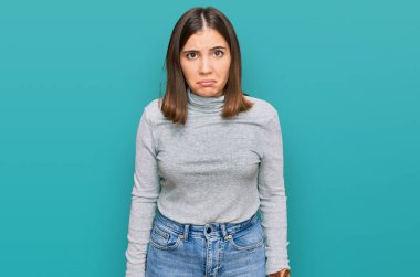 Balıkçı yaka kazak giyen genç ve güzel bir kadın depresif ve endişeli, sinirli ve korkmuş bir şekilde ağlıyor. hüzünlü ifade. 