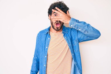 Kıvırcık saçlı ve ayılı yakışıklı bir adam sıradan bir kot ceket giyiyor. Şok geçiriyor, yüzünü ve gözlerini eliyle kapatıyor, utangaç bir ifadeyle parmaklarından bakıyor.. 