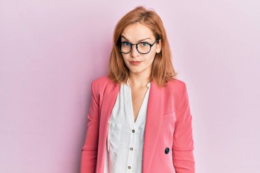 İş stili takan, gözlüklü, şüpheci ve gergin genç beyaz bir kadın sorun yüzünden surat asıyor. negatif kişi. 