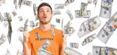 Mutluluk mesajı içeren ayı tişörtü giyen yakışıklı genç adam şaşırmış ve şaşırmış bir şekilde yukarı bakıyor ve parmaklarıyla işaret ediyor ve kollarını kaldırıyor..