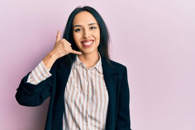 İş kıyafetleri giymiş, gülümseyen, el ve parmaklarıyla telefonla konuşan İspanyol bir kız. iletişim kavramları. 