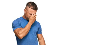 Yakışıklı, sıradan kıyafetler giyen, burnu ve gözleri ovuşturmaktan yorgun, yorgun ve başı ağrıyor. Stres ve hüsran kavramı. 