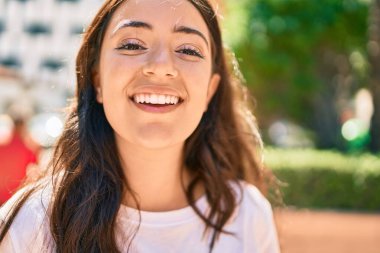 Genç İspanyol kadın gülümseyerek şehirde mutlu mesut yürüyor..