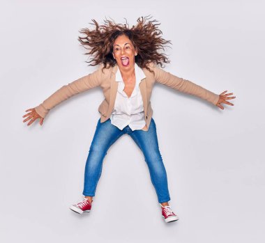 Zarif kıyafetler giyen genç ve güzel İspanyol iş kadını bunu ağzıyla kutluyor. İzole edilmiş beyaz arkaplan üzerinden atlama