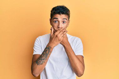 Gündelik beyaz tişört giyen genç ve yakışıklı Afro-Amerikalı adam yanlışlıkla ağızlarını kapatarak şok geçirdi. gizli kavram. 