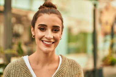 Güzel esmer kadın güler yüzlü mutlu ve kendinden emin sonbaharın güneşli bir gününde şehirde.