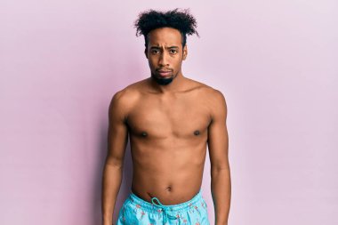 Sakallı, mayo giyen, kuşkucu ve gergin genç Afro-Amerikalı bir adam sorun yüzünden üzgün. negatif kişi. 