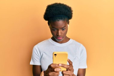 Genç Afro-Amerikalı kız akıllı telefon ve kulaklık kullanıyor. Depresyonda ve endişe içinde. Kızgın ve korkmuş. hüzünlü ifade. 