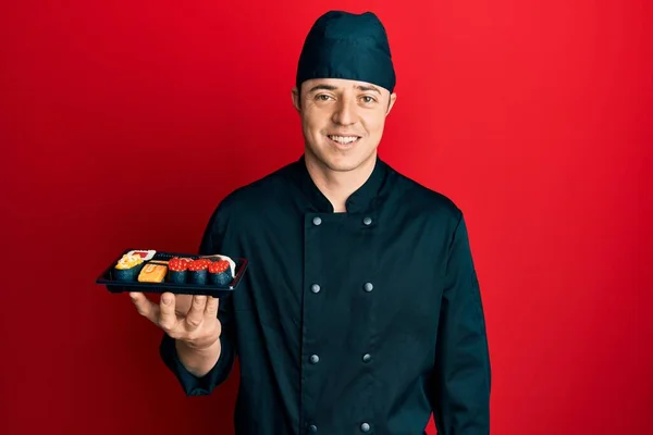 Handsome Young Man Wearing Chef Uniform Holding Plate Sushi Looking — Stock Photo, Image