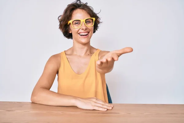 Jonge Spaanse Vrouw Casual Kleding Een Bril Zittend Tafel Glimlachend — Stockfoto