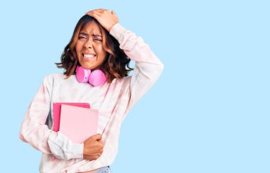 Kulaklık takan, kafası karışmış, şaşırmış ve kızgın yüzlü güzel, melez bir kadın. 