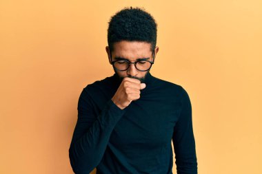 Balıkçı yaka kazak giyen, sakallı yakışıklı, kendini iyi hissetmeyen ve soğuk algınlığı veya bronşitin belirtisi olarak öksüren bir adam. sağlık hizmeti kavramı. 