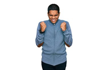 Kolları havada ve gözleri kapalı zaferi kutlamak için gülümseyen sıradan bir tişört giyen genç, yakışıklı İspanyol. Kazanan konsept. 