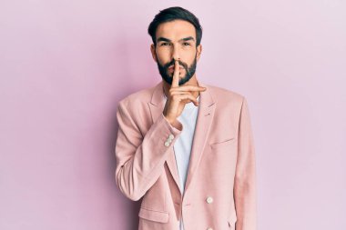 İş ceketi giymiş genç bir İspanyol dudakları parmaklarıyla sessiz olmak istiyor. sessizlik ve gizli konsept. 