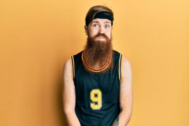 Uzun sakallı, basketbol forması giyen, komik suratlı kızıl saçlı adam. Havayla şişmiş ağız, çılgın bir ifade.. 