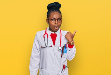 Doktor üniforması ve steteskop giyen genç Afro-Amerikan kadın elini kaldırdığında şaşırdı ve ağzı açık kaldı.. 