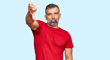 Orta yaşlı, sıradan kıyafetler giyen, mutsuz görünen, reddedilmiş ve olumsuz davranan yakışıklı bir adam. kötü ifade. 