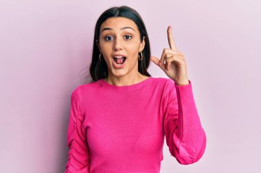 Gündelik kıyafetler giyen genç İspanyol kadın başarılı bir fikri işaret ediyor. Heyecanlı ve mutlu. Bir numara.. 