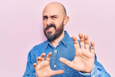 Gayri resmi giyinen genç yakışıklı adam tiksinti ifadesi takınıyordu. Tiksinti tepkisi yüzünden tiksinti ve korku ifadesi takınıyordu. Eller havada. 