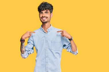 Günlük kıyafetler giyen, kendine güveni olan, kendini gururlu ve mutlu gösteren genç İspanyol bir adam.. 