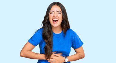 Güzel, esmer, sıradan kıyafetler giyen genç bir kadın. Yüksek sesle gülümsüyor ve kahkaha atıyor. Çünkü elleri vücutta komik, çılgın bir şaka.. 