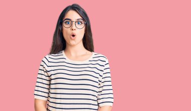 Esmer, sıradan kıyafetler ve gözlük takan genç bir kız. Şaşırmış ve korkmuş bir ifade, korku ve heyecanlı bir yüz ifadesi var.. 