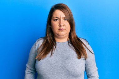 Güzel esmer, iri yarı, gündelik kıyafetler giyen şüpheci ve gergin, sorun yüzünden surat asan bir kadın. negatif kişi. 