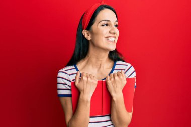 Genç İspanyol kadın elinde kitapla gülüyor ve kahkahalarla gülüyor.. 