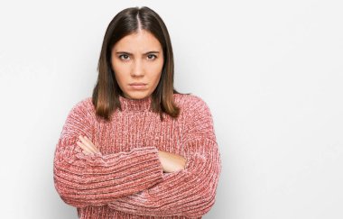 Gündelik kıyafetler giyen, kuşkucu ve gergin genç ve güzel bir kadın. Yüzünde çapraz kollarla onaylamayan bir ifade var. negatif kişi. 