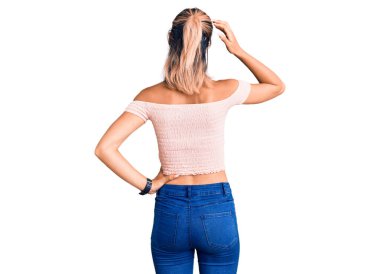 Genç ve güzel bir kadın günlük kıyafetlerini ters giyip elleri kafasında şüpheyi düşünüyor. 