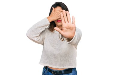 Güzel İspanyol kadın, sıradan bir süveter giyip elleriyle gözlerini kapatıyor ve üzgün ve korku ifadeleriyle jest yapıyor. utangaç ve olumsuz kavram. 