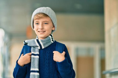 Sevimli sarışın öğrenci okulda mutlu bir şekilde gülümsüyor..