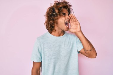 Latin asıllı genç adam günlük kıyafetler giyip el ele tutuşarak bağırıyor ve çığlık atıyordu. iletişim konsepti. 