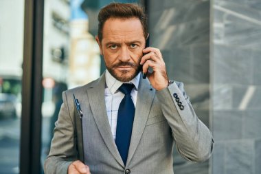 Şehirdeki akıllı telefondan konuşan orta yaşlı bir işadamı..